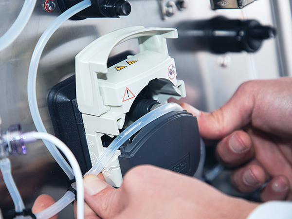Hands arranging single use hoses on a panel