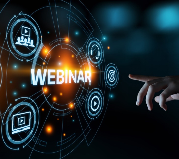 Hand pointing towards a digital interface with glowing icons representing online communication, video, and learning, centered around the word 'WEBINAR' in bold letters